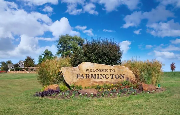 Welcome to Farmington stone entrance sign with green landscape in Farmington, Arkansas