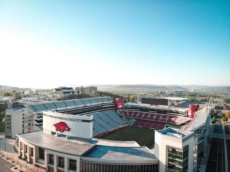 Aerial view of Donald W. Reynolds Razorback Stadium at the University of Arkansas in Fayetteville with the Ozark Mountains in the background